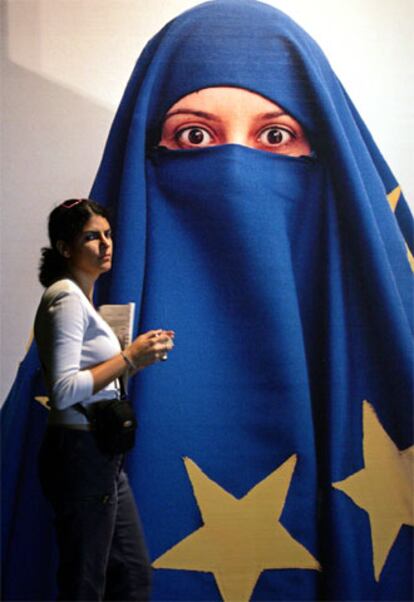 Una mujer pasa ante un mural que representa a una ciudadana turca velada con la bandera europea.