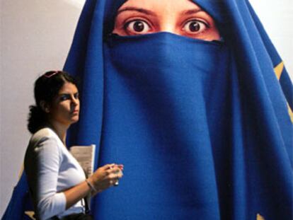 Una mujer pasa ante un mural que representa a una ciudadana turca velada con la bandera europea.