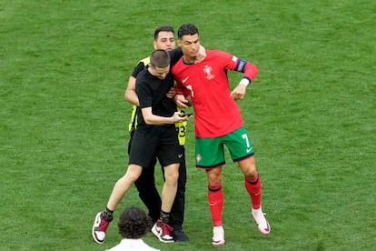 Un espontáneo, con Cristiano durante el partido entre Portugal y Turquía el pasado 22 de junio en Dortmund.