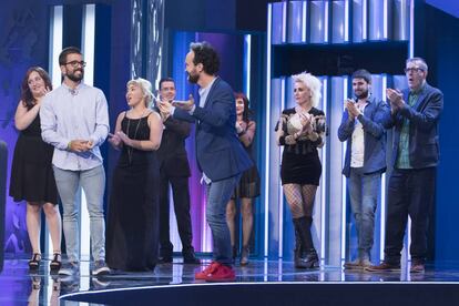 El presentador Juan Antonio Simarro, con batuta, se dirige a un concursante durante el programa mientras aplaude el jurado.