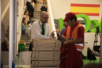 Un repartidor de una pizzería llega a la sede de Vox durante la noche electora.