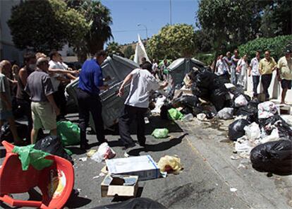 Vecinos de Torre del Mar desparraman las basuras acumuladas por la huelga en las calles del núcleo turístico.