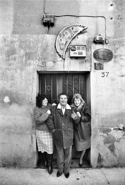 Retrato de un hombre con dos mujeres en la puerta de un bar en el barrio de San Vicente.