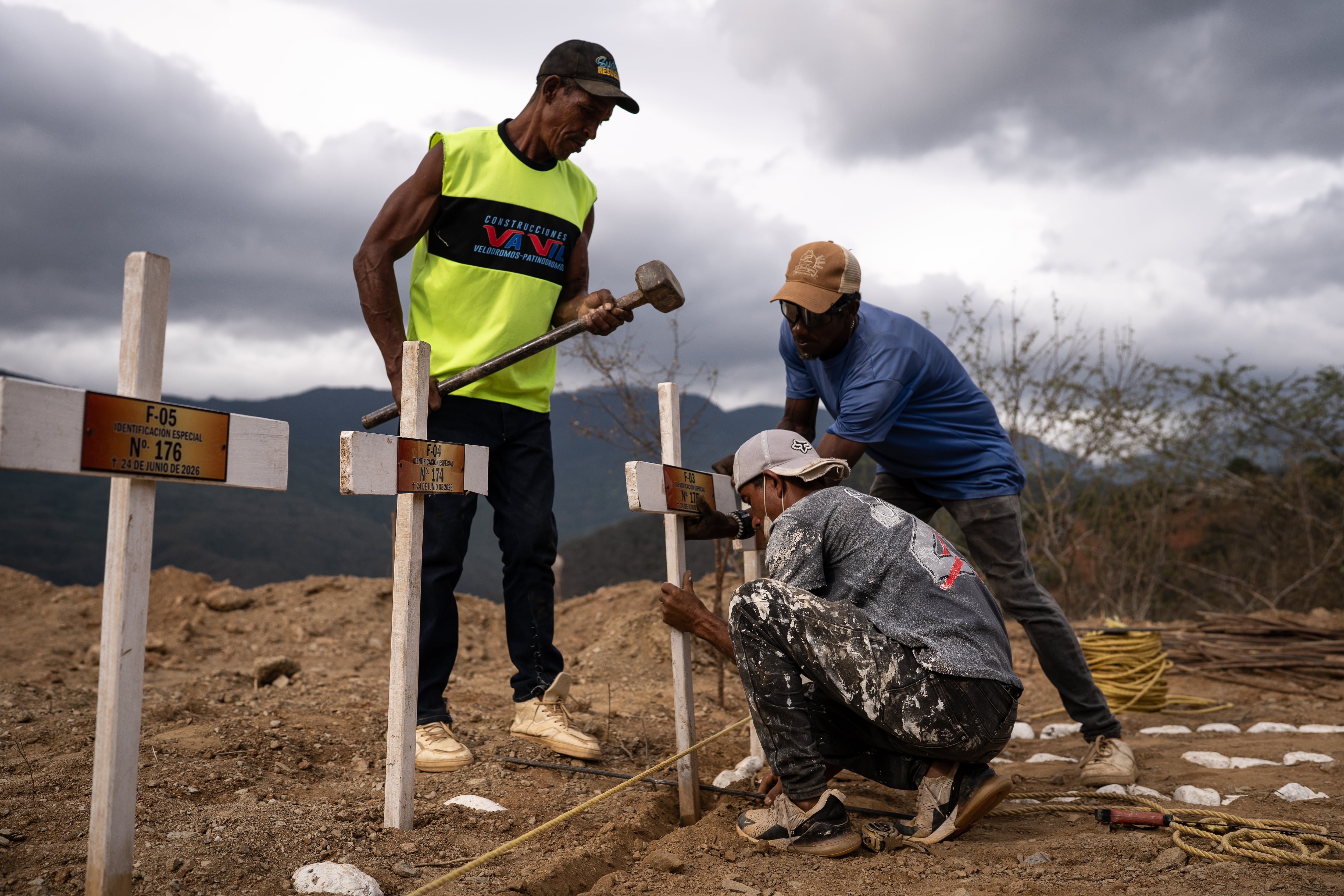Un grupo de trabajadores instalan las cruces sobre las tumbas de los cuerpos sin identificar.