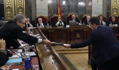 El coordinador la defensa dels exconsellers del PDeCAT i exconseller de Presidència Francesc Homs (esq.) intercanvia un document amb l'expresident de l'ANC i diputat de JxCat Jordi Sànchez, a l'inici del judici al procés.