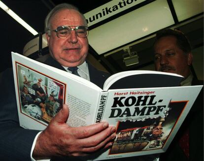 Helmut Kohl sonríe mientras hojea un libro del alemán Horst Haitzinger, titulado 'Kohldampf', en la feria del libro de Francfort (Alemania). el 17 de octubre de 1997.  