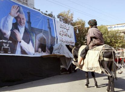 Un niño contempla un cartel del actual presidente afgano, Hamid Karzai, en Herat, al oeste del país.