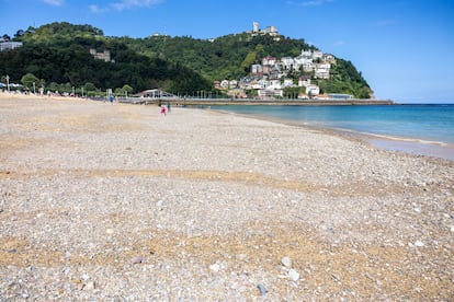 La playa de Ondarreta, este viernes 22 de agosto, cubierta por piedras y cascotes, con el monte Igeldo al fondo.
