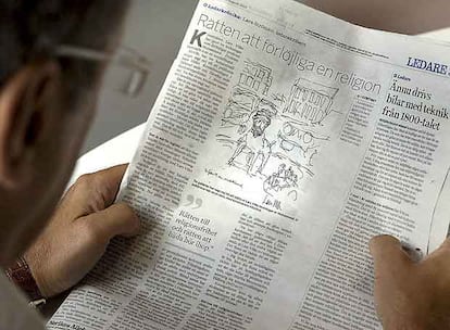 Un hombre lee el diario sueco que muestra una caricatura de Mahoma con cuerpo de perro.