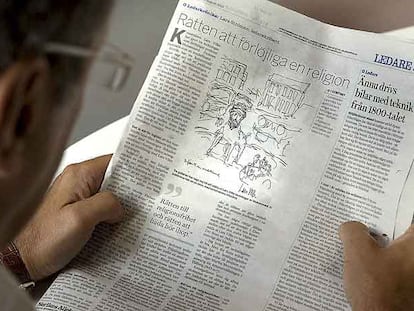 Un hombre lee el diario sueco que muestra una caricatura de Mahoma con cuerpo de perro.