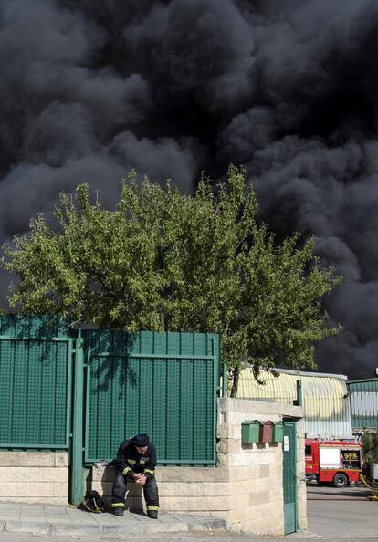 Bombero descansa en las inmediaciones de la planta de reciclaje incendiada de Chiloeches.