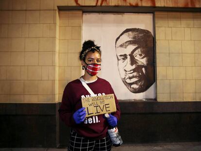 Una empleada del Museo de Oakland, delante de un mural de George Floyd durante una protesta en dicha ciudad contra su muerte.