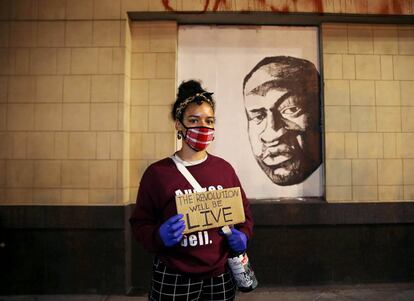 Una empleada del Museo de Oakland, delante de un mural de George Floyd durante una protesta en dicha ciudad contra su muerte.