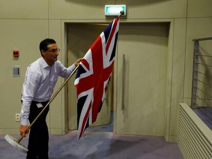 Un funcionario coloca la bandera británica para la rueda de prensa de los negociadores del 'brexit'. REUTERS/Francois Lenoir