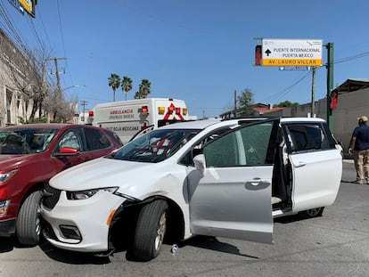 A member of the Mexican security forces stands next to a white minivan with North Carolina plates and several bullet holes, at the crime scene where gunmen kidnapped four US citizens.