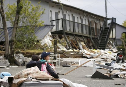 Estudiantes universitarios frente a sus apartamentos destrozados por el terremoto en la ciudad de Minamiaso, Kumamoto, al sur de Japón