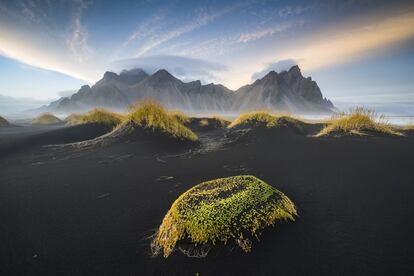 Esta praia do sul da Islândia tem um singular sistema de dunas de areia vulcânica coroadas pelo afiado perfil das montanhas costeiras. Aqui, com a luz do céu de um entardecer outonal.