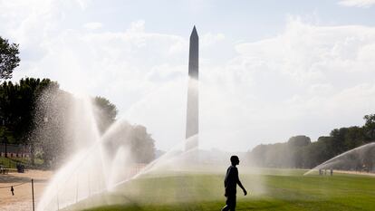 Una persona camina entre aspersores delante del monumento a Washington en plena ola de calor en Washington DC, Estados Unidos, este 8 de septiembre.