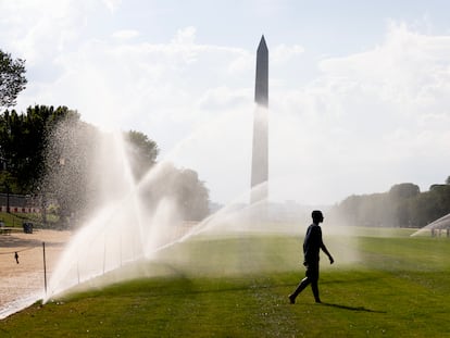 Una persona camina entre aspersores delante del monumento a Washington en plena ola de calor en Washington DC, Estados Unidos, este 8 de septiembre.