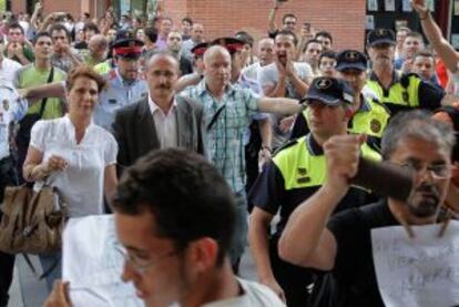 El alcalde de Mollet sale de un pleno escoltado por la policía.