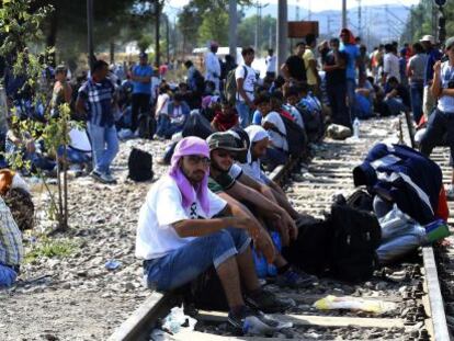Migrantes esperan para cruzar la frontera entre Macedonia y Grecia, este jueves.