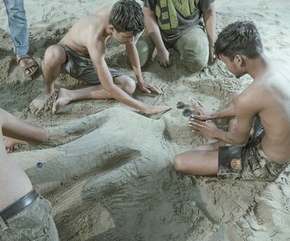 Un grupo de niños hace esculturas en la arena en esta playa en la bahía de Bengala.