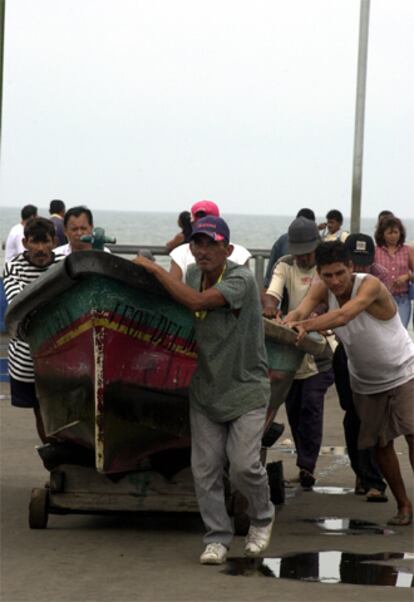 Trabajadores del puerto Libertad, en El Salvador, retiran las embarcaciones ante la llegada de la tormenta.