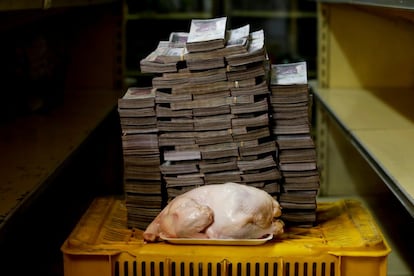 Un pollo de 2,4 kilos frente a una montaña de billetes que suman su precio —un equivalente de 1,95 euros—, en un mercado de Caracas (Venezuela), el 16 de agosto de 2018. En julio, el FMI proyectó una inflación del 1.000.000% este año en Venezuela, comparando la situación con la Alemania de 1923 o Zimbabue de 2008. Antes de la reconversión monetaria promovida por el gobierno de Nicolás Maduro en agosto, que dio entrada al bolívar soberano, el billete de mayor denominación era el de 100.000 bolívares, cantidad que alcanzaba para pagar una fotocopia o comprar un huevo.