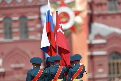 Miembros de la Guardia de Honor rusa portan una bandera nacional y una réplica de la bandera de la Victoria.