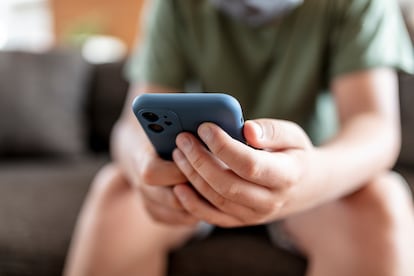 teenager boy is using smartphone at home - home schooling