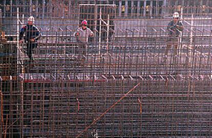 Tres trabajadores preparando un encofrado en las obras de la zona del Fòrum 2004.