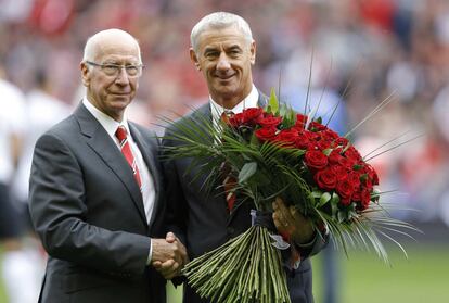 Bobby Charlton e Ian Rush, jugadores legendarios del United y el Liverpool respectivamente, posan con una ramo de 96 rosas rojas en honor a los fallecidos.