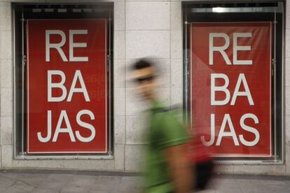 Un hombre pasa ante un comercio en rebajas