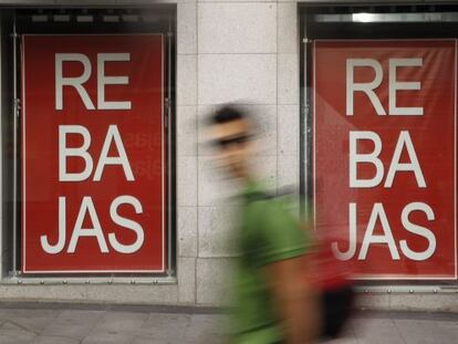 Un hombre pasa ante un comercio en rebajas