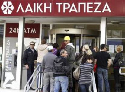 Varias personas hacen cola a las puertas de una sucursal del Banco Laiki en Nicosia (Chipre). EFE/Archivo