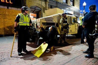 Una manifestante se arrodilla ante la policía este domingo en Boston.