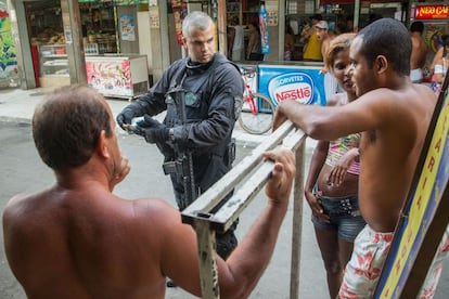 Policiais do CORE (Coordenadoria de Recursos Especiais da Polícia Civil) conferem os documentos de moradores do Complexo da Maré, no Rio de Janeiro. A ocupação faz parte do processo de instalação das Unidades de Polícia Pacificadora (UPP) no local.