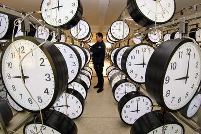 Un técnico comprueba el funcionamiento de varios relojes en un taller de una empresa en Yantai, en la provincia de Shandong, al este de China.