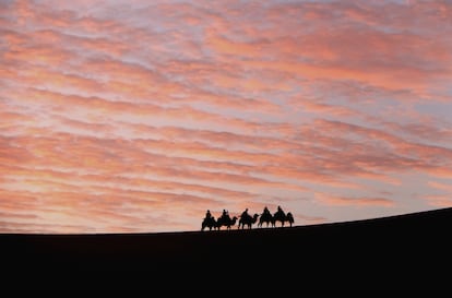 Turistas en camello por las dunas de Mingsha, en China.