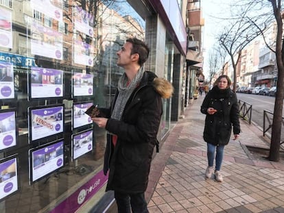 A young man reads property listings in Madrid.