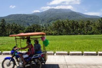 Verde arrozales ante un volcán en la isla de Camiguín, en Filipinas.