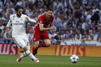 El centrocampista del Real Madrid Isco Alarcón (izquierda) disputa un balón con el centrocampista español del Bayern Múnich Xabi Alonso.