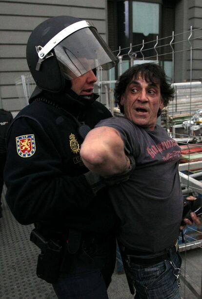 Un agente de policía detiene a un manifestante durante la protesta en la plaza de Neptuno, Madrid.