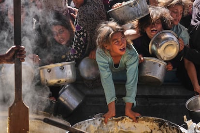 Niños palestinos tratan de hacerse con una ración de comida en un reparto de alimentos en Jan Yunis este viernes. 