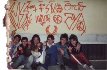 Punks sentados bajo una pared con sus firmas.