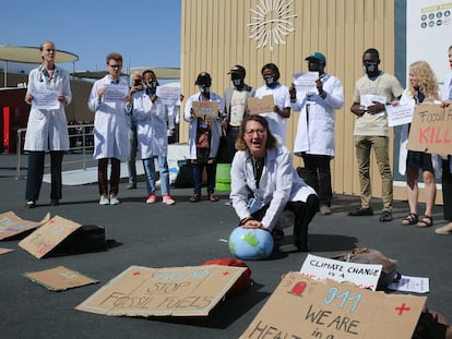 Un trabajador médico realiza una "respiración artificial" simbólica en un globo terráqueo durante una protesta por el efecto del cambio climático en cuestiones de salud en la Cumbre del Clima de la ONU COP27, el viernes 11 de noviembre de 2022, en Sharm el-Sheij, Egipto.