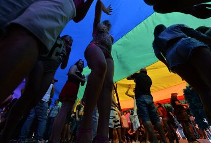 Grupo abaixo da bandeira que representa o movimento GLBT, da 18ª edição da Parada Gay em São Paulo, neste domingo.