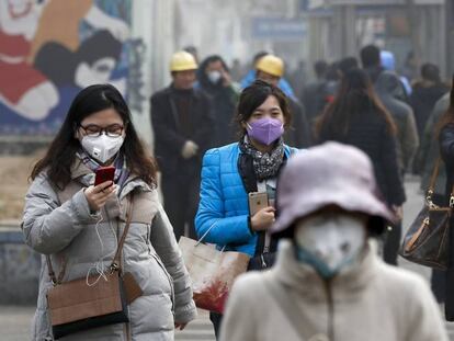 Varias mujeres ataviadas con mascarillas en Pek&iacute;n.