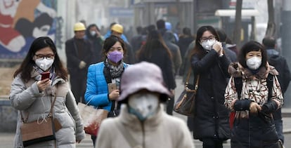 Varias mujeres ataviadas con mascarillas en Pek&iacute;n.