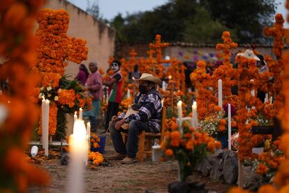 Familiares se preparan para pasar la noche junto a la tumba de sus seres queridos en el cementerio de Arocutín en el Estado de Michoacán.